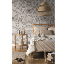 Spálňa s posteľou, nočným stolíkom, lampou a tapetou s motýľovým vzorom