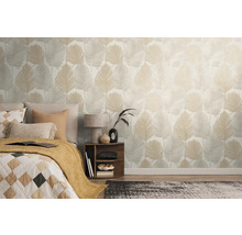 Spálňa s posteľou a stenou s tapetou s listami.