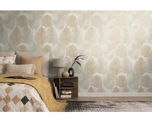 Spálňa s posteľou a stenou s tapetou s listami.