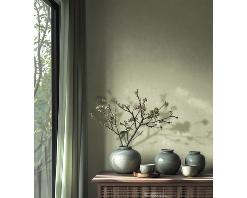 Dekoratívne vázy a misky na drevenej skrinke vedľa okna