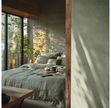 Spálňa s posteľnou bielizňou, vankúšmi, nápojom a prirodzeným svetlom