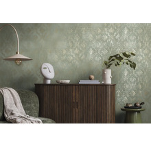 Dekoratívna obývacia izba s komodou, lampou a doplnkami pred vzorovanou tapetou