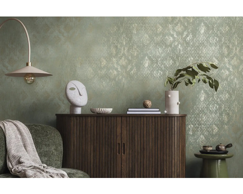 Dekoratívna obývacia izba s komodou, lampou a doplnkami pred vzorovanou tapetou