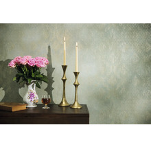 Dekoratívne aranžmán s ružami, sviečkami a starožitnými prvkami na stole pred vzorovanou stenou