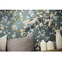 Detailný záber steny s kvetinovou tapetou, vankúšmi a dekoratívnymi vázami.