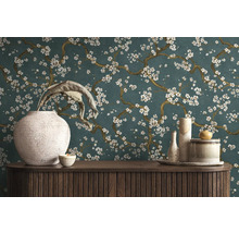 Dekoratívny interiér s komodou, vázami a kvetinovou tapetou.