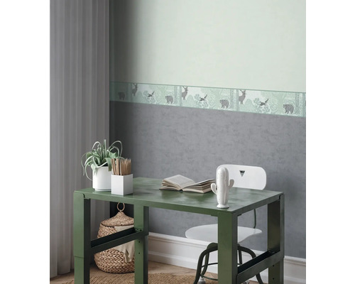 Dekoratívna detská izba so stolom, stoličkou a bordúrou tapety s motívom lesa.