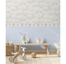 Detská izba s tapetou s motívmi oblakov a drevenými hračkami