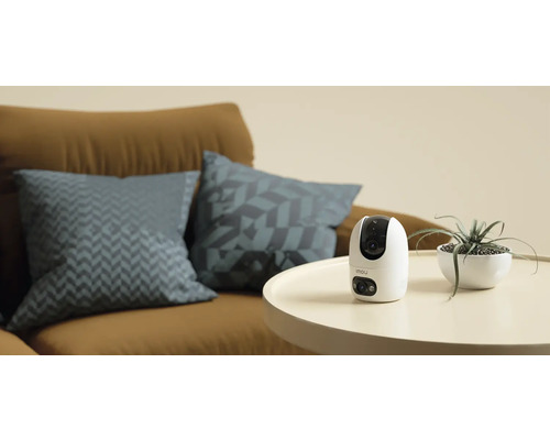Kamera Imou na stole vedľa izbovej rastliny a pohovky