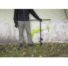 Osoba so zemným vrtákom v záhrade