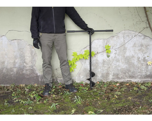 Osoba so zemným vrtákom v záhrade