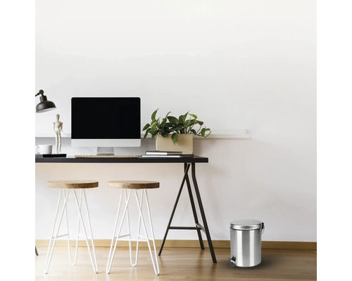 Scéna so stolom, stoličkami a kovovým odpadkovým košom s pedálom