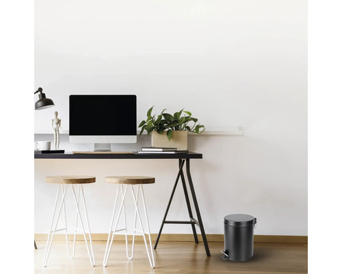 Pracovňa so stolom, stoličkami a okrúhlym odpadkovým košom.