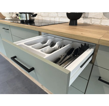 Kuchynská zásuvka s vložkou na príbory v svetlej kuchyni.