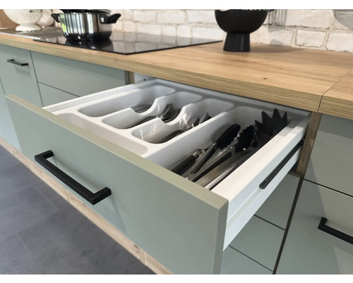 Kuchynská zásuvka s vložkou na príbory v svetlej kuchyni.