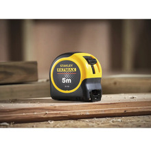 Zvinovací meter Stanley Fatmax s dĺžkou 5 metrov na drevenom tráme