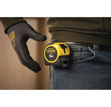 Zvinovací meter Stanley Fatmax s dĺžkou päť metrov pripevnený k pásu nohavíc