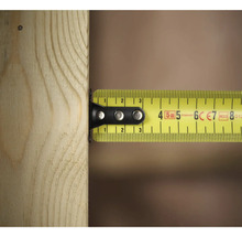 Žltý zvinovací meter meria kus dreva