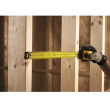 Žltý zvinovací meter meria drevené trámy