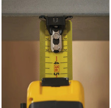 Žltý zvinovací meter s magnetickou sponou na upevnenie na kovové povrchy