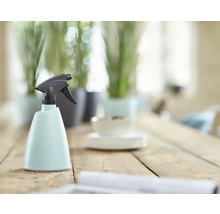 Plastová rozprašovacia fľaša s rozprašovacou hlavicou na drevenom stole