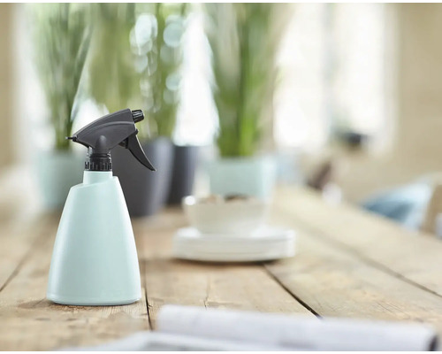 Plastová rozprašovacia fľaša s rozprašovacou hlavicou na drevenom stole