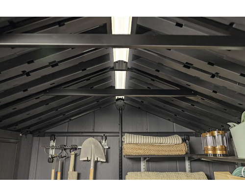 Vnútorný pohľad na záhradný domček s policami, náradím a osvetlením