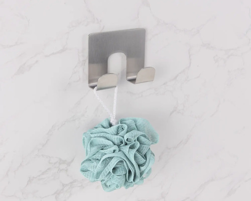 Sprchová huba visí na nerezovom nástennom háku