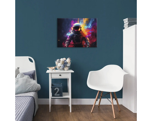 Dekoratívna detská izba s obrázkom astronauta na modrej stene nad nočným stolíkom.