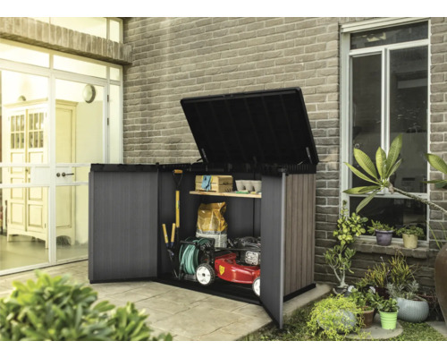 Otvorená skriňa na náradie so záhradným náradím a kosačkou na trávu