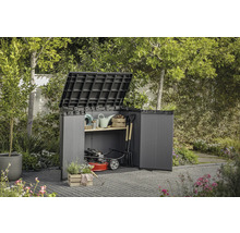 Záhradná skriňa s otvorenými dverami a vyklopeným vekom, vyplnená záhradným náradím a kosačkou na trávu