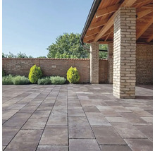 Záhrada s dlažobnými kockami, múrom a malým altánkom s drevenou konštrukciou.