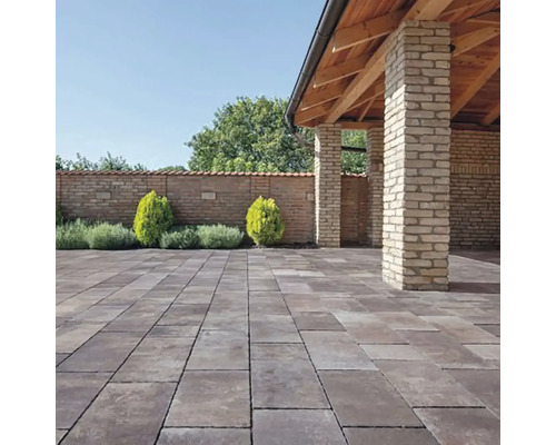 Záhrada s dlažobnými kockami, múrom a malým altánkom s drevenou konštrukciou.