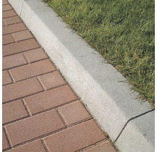 Detail dlažobných dosiek vedľa okraja trávnika.