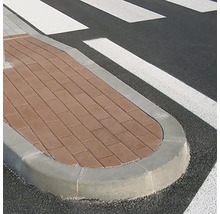 Obrubník s dlažobnými kockami pri priechode pre chodcov.