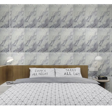 Spálňa s obkladovými dlaždicami vzhľadu mramoru za posteľou