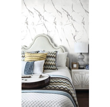 Spálňa s posteľou, nočným stolíkom a tapetou s mramorovým vzorom