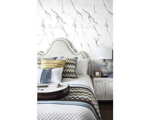 Spálňa s posteľou, nočným stolíkom a tapetou s mramorovým vzorom