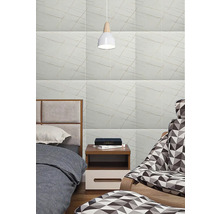 Spálňa s obkladom stien vo vzhľade mramoru, posteľou, nočným stolíkom a lampou