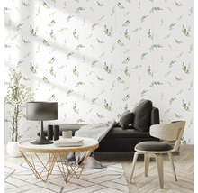 Obývacia izba s kvetinovým vzorom na stene, pohovkou, stolom, stoličkou a kobercom pre svetlú a priateľskú atmosféru.