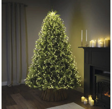 Ozdobený vianočný stromček so svetelnou reťazou v obývacej izbe.