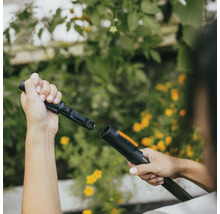 Osoba pripája záhradné náradie na zavlažovanie záhrady