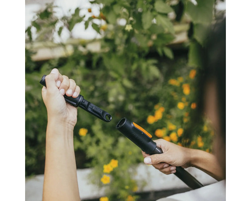 Osoba pripája záhradné náradie na zavlažovanie záhrady