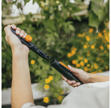 Dve ruky spájajú zavlažovací systém Fiskars.