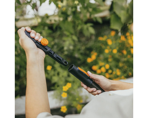 Dve ruky spájajú zavlažovací systém Fiskars.