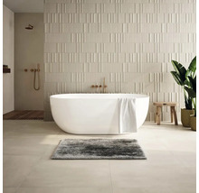 Moderná kúpeľňa s voľne stojacou vaňou, štruktúrovanými obkladačkami a drevenými prvkami.