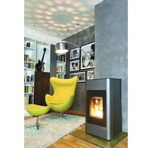 Obývacia izba s krbovými kachľami, kreslom, stojacou lampou a knižnicou