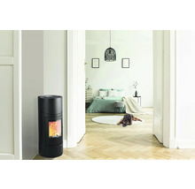 Interiér s čiernymi krbovými kachľami a výhľadom do spálne.