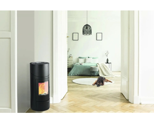 Interiér s čiernymi krbovými kachľami a výhľadom do spálne.