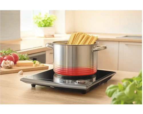 Nerezový hrniec so špagetami na indukčnej varnej doske v kuchyni